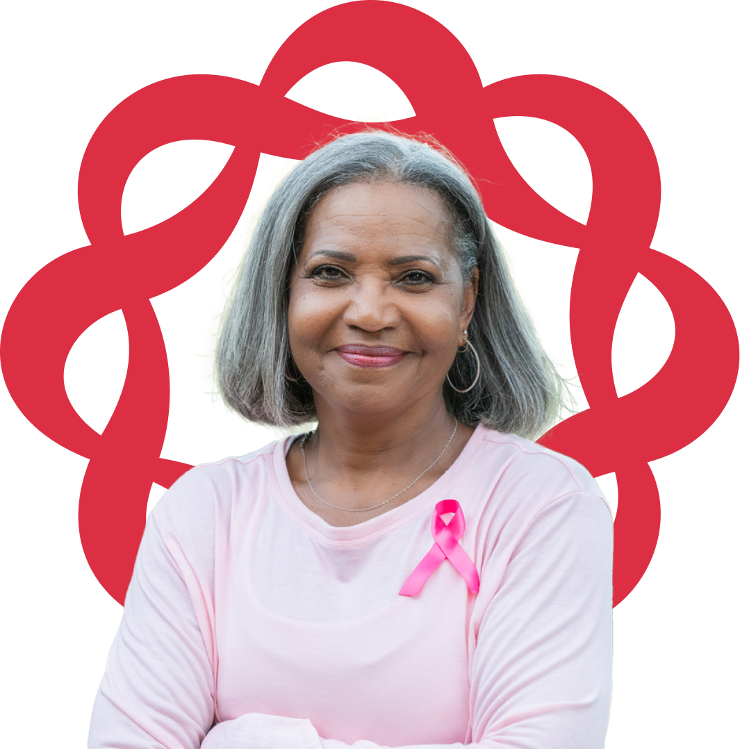 Woman with a pink shirt and pink bow standing in front of the Breastcancer.org logo for Triple Negative Breast Cancer awareness